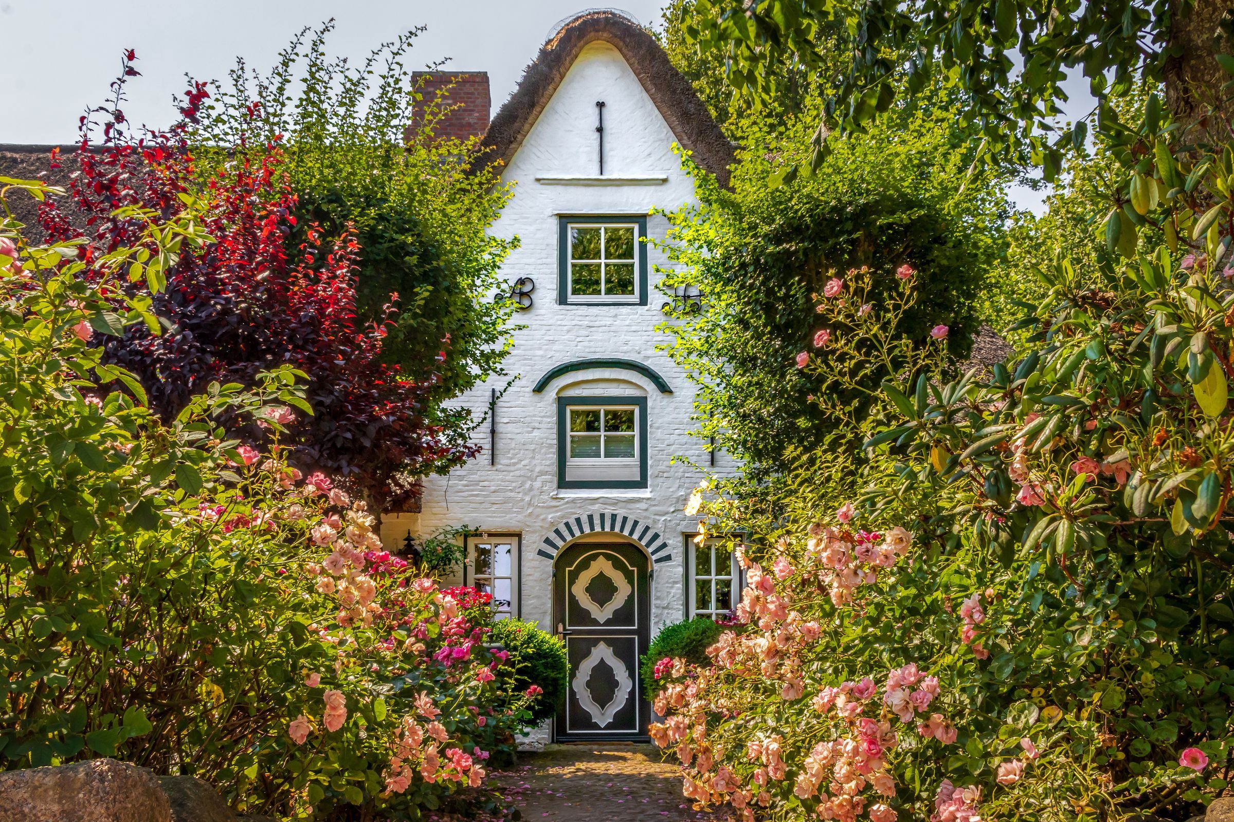 Haus mit Bauerngarten, Staudenbeeten und geschnittenen Hecken